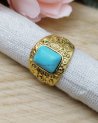 Grosse bague dorée avec une pierre rectangulaire