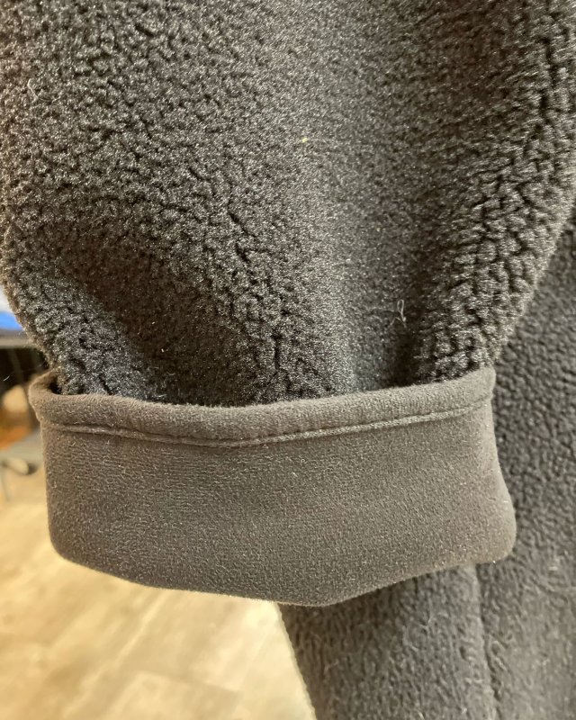 Manteau long en moumoute noire avec une capuche