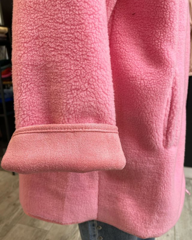 Manteau long en moumoute rose avec une capuche