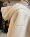 Manteau long en moumoute écru avec une capuche