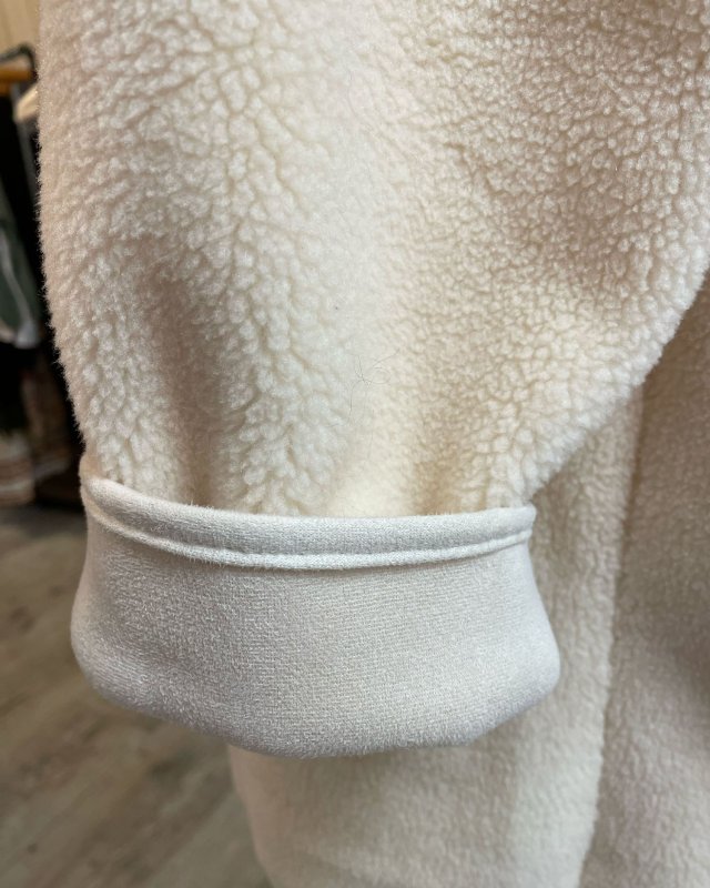 Manteau long en moumoute écru avec une capuche
