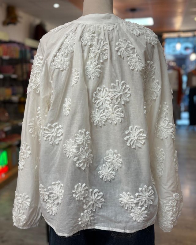 Chemisier blanc avec des fleurs en relief