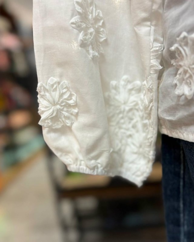 Chemisier blanc avec des fleurs en relief