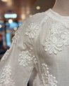 Chemisier blanc avec des fleurs en relief