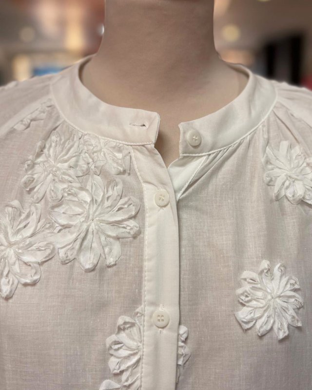 Chemisier blanc avec des fleurs en relief