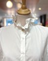 Chemisier blanc avec un col volanté à bouton doré