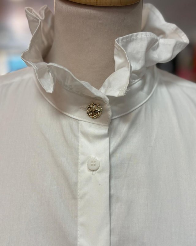 Chemisier blanc avec un col volanté à bouton doré