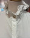 Chemisier blanc avec un col volanté à bouton doré