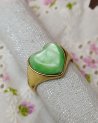 Bague dorée avec une pierre verte en forme de coeur