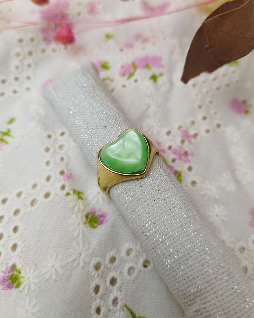 Bague dorée avec une pierre verte en forme de coeur