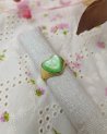 Bague dorée avec une pierre verte en forme de coeur