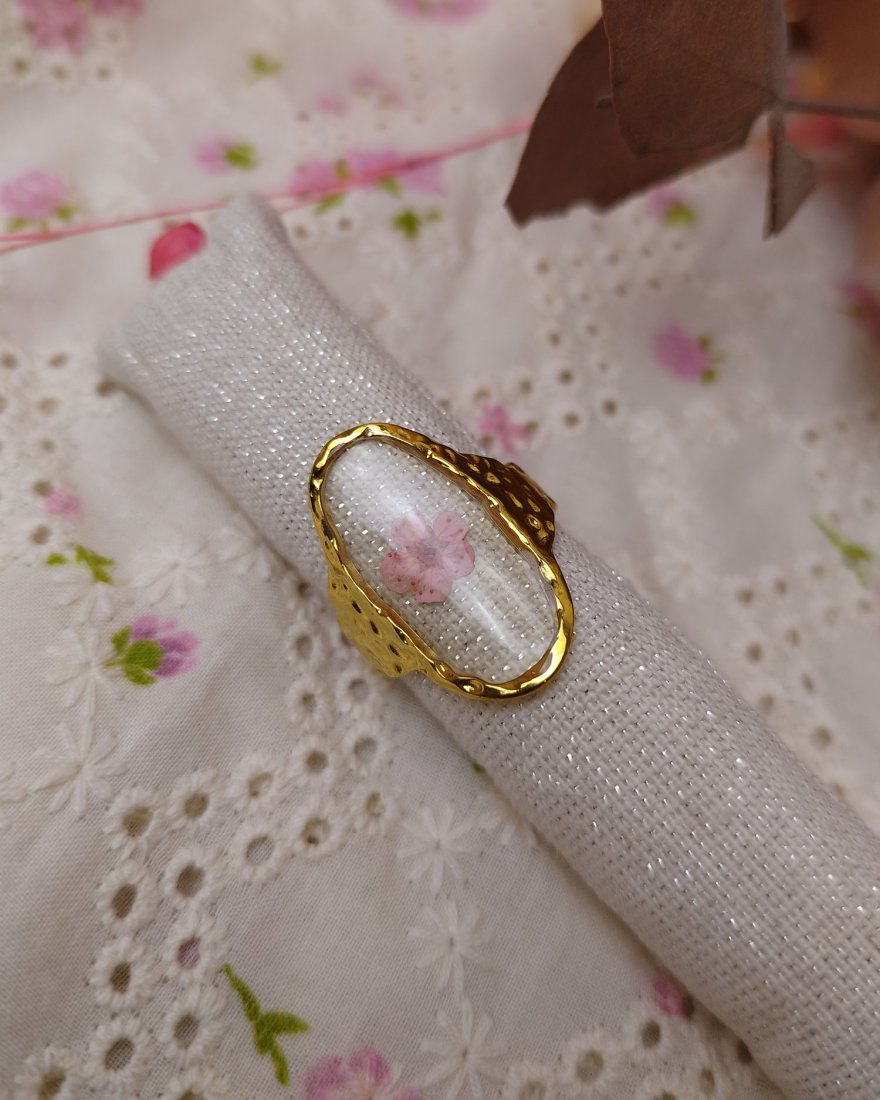 Bague ovale transparente avec une fleur séchée rose