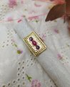Bague rectangulaire dorée avec des pierres roses