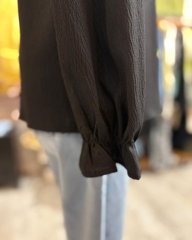 Blouse noire à dos échancré avec des détails en dentelle