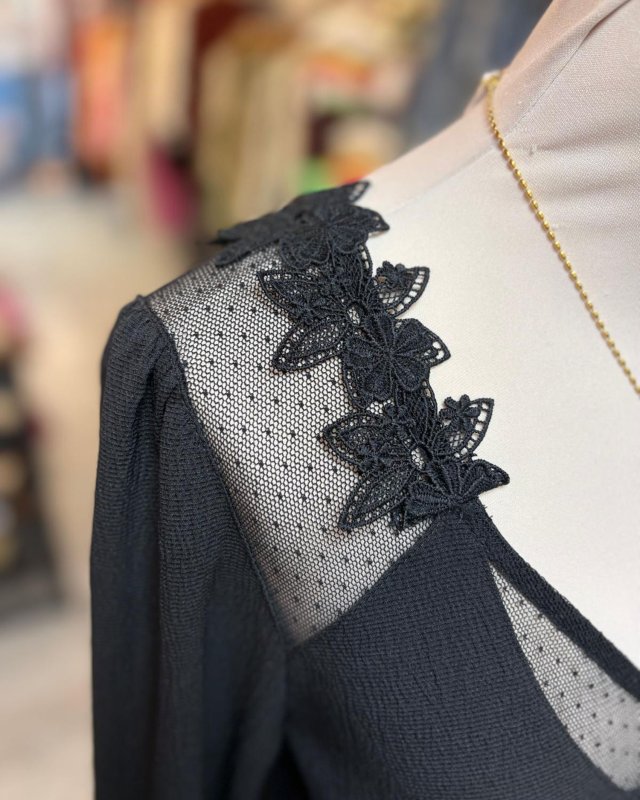 Blouse noire à dos échancré avec des détails en dentelle