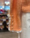 Pull en maille orange avec des finitions en dentelle blanche