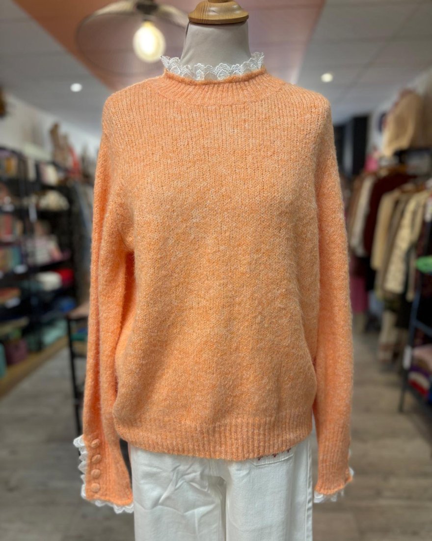 Pull en maille orange avec des finitions en dentelle blanche