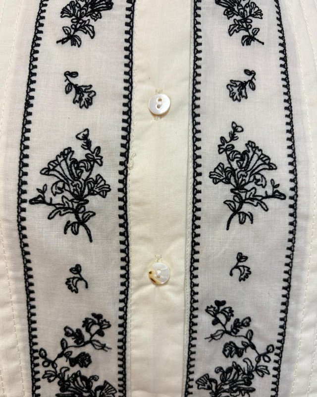 Chemisier blanc plissé avec des broderies noires