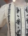 Chemisier blanc plissé avec des broderies noires
