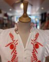Chemisier blanc sans manches avec des broderies fleuries