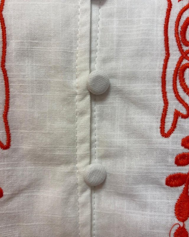 Chemisier blanc sans manches avec des broderies fleuries