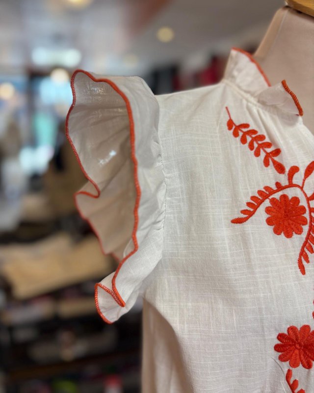Chemisier blanc sans manches avec des broderies fleuries